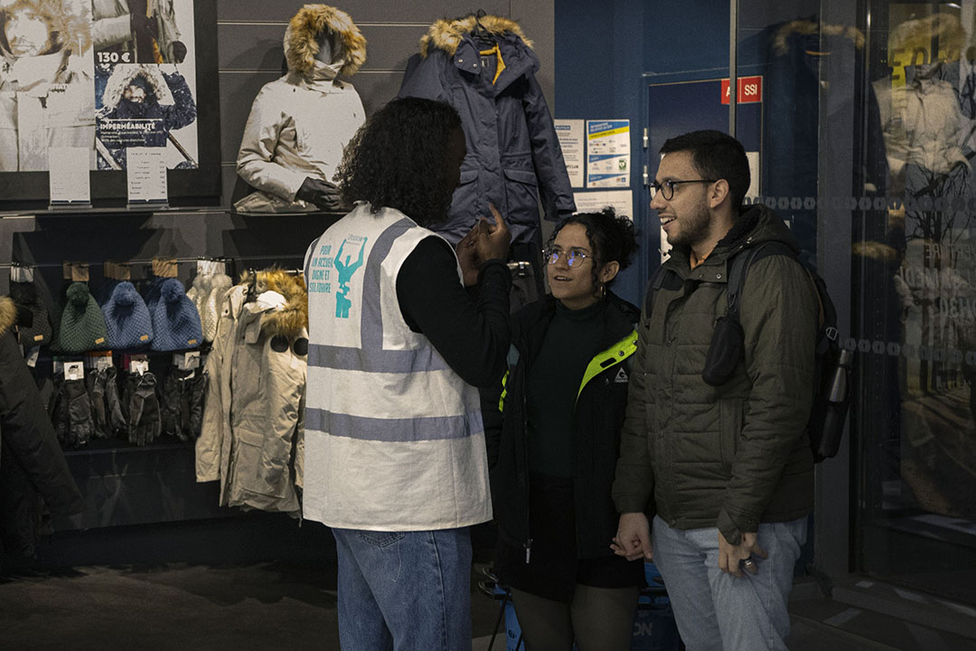 Des bénévoles d'Utopia 56 organisent une collecte de dons dans un magasin à Noël.