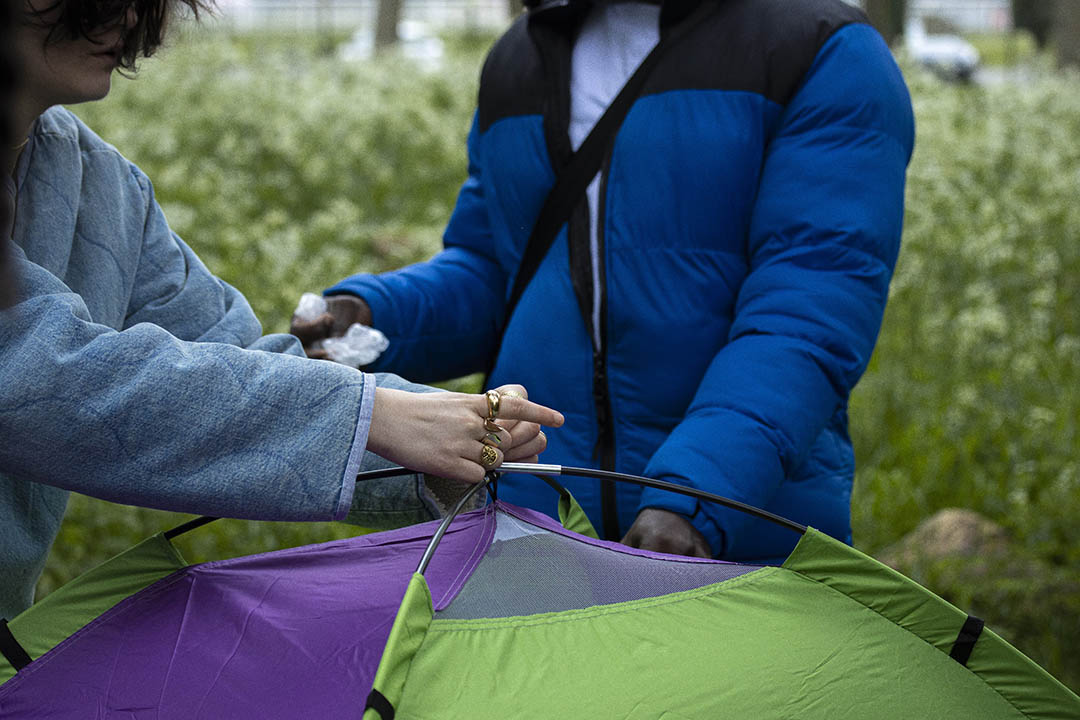 Une bénévole de l'association humanitaire Utopia 56 installe une tente pour une jeune exilé à Lille